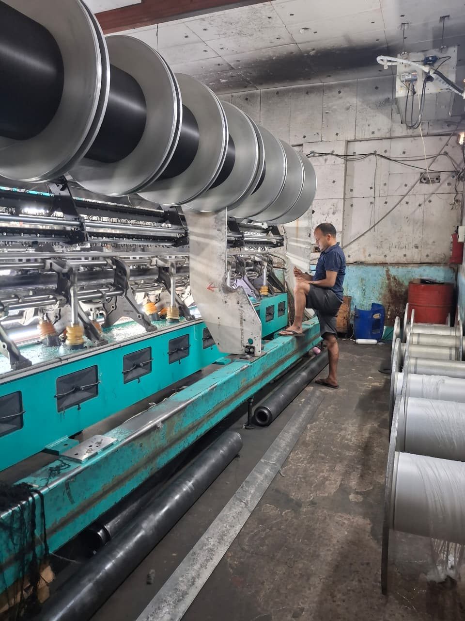 Trustex operator running a warp-knitting machine